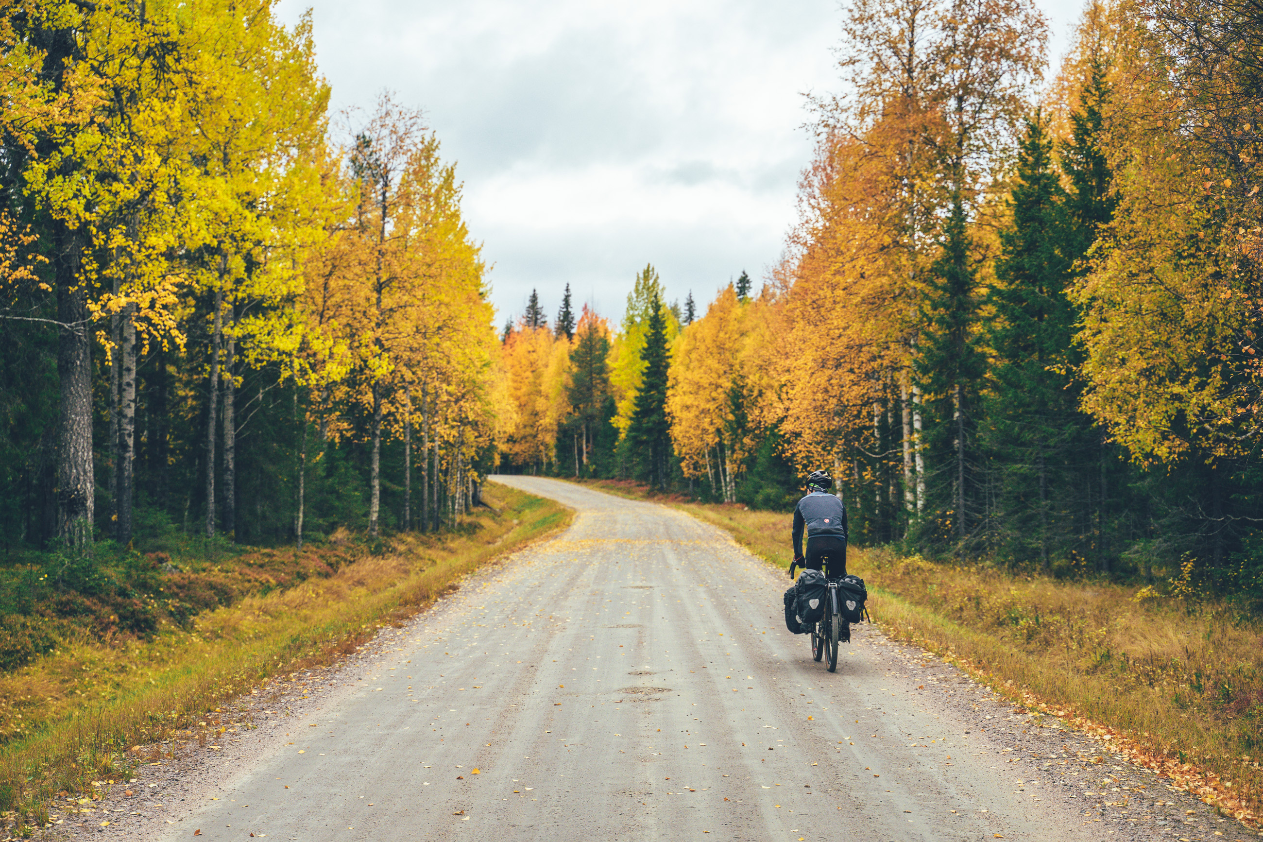 Cyclist riding on gravel road in the fall