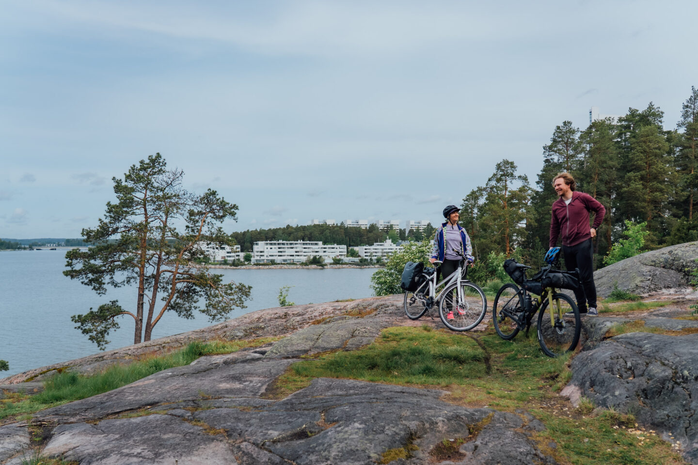 Two cyclists taking a break on a cliff next to the seaside