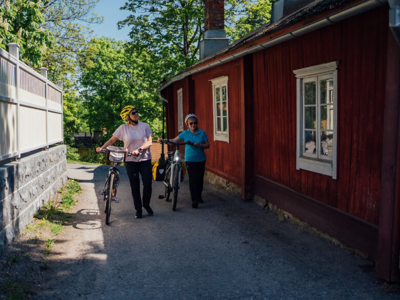 cyclist walking by the old wooden houses