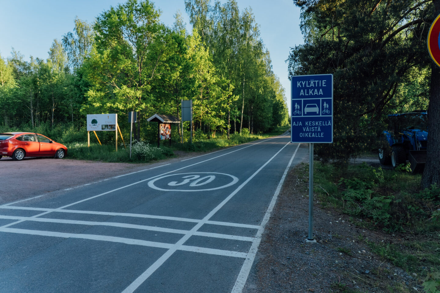 A paved village road with cycle roads on both sides, and a signpost indicating it