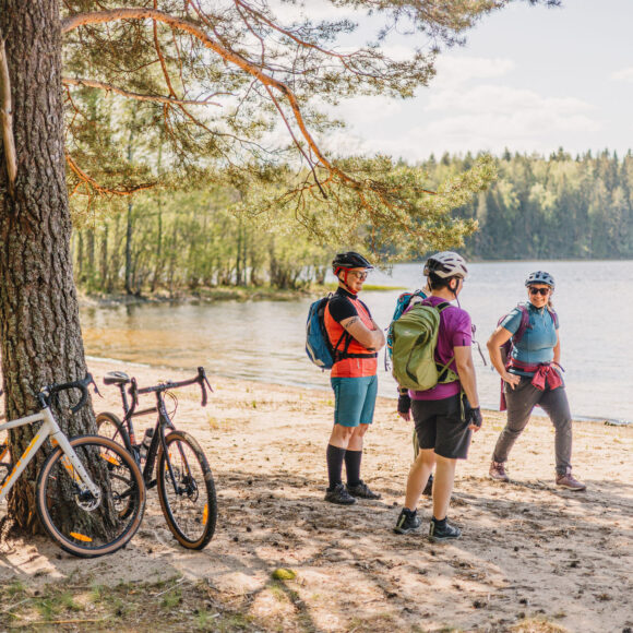 Pyöräilijät järven rannalla.