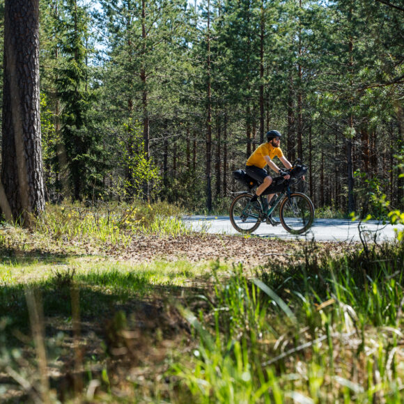 Pyöräilijä metsässä.