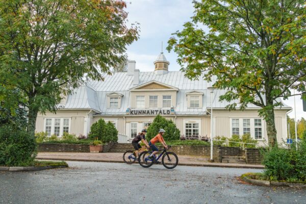 Kaksi pyöräilijää ohittaa Punkalaitumen vanhan kunnantalon