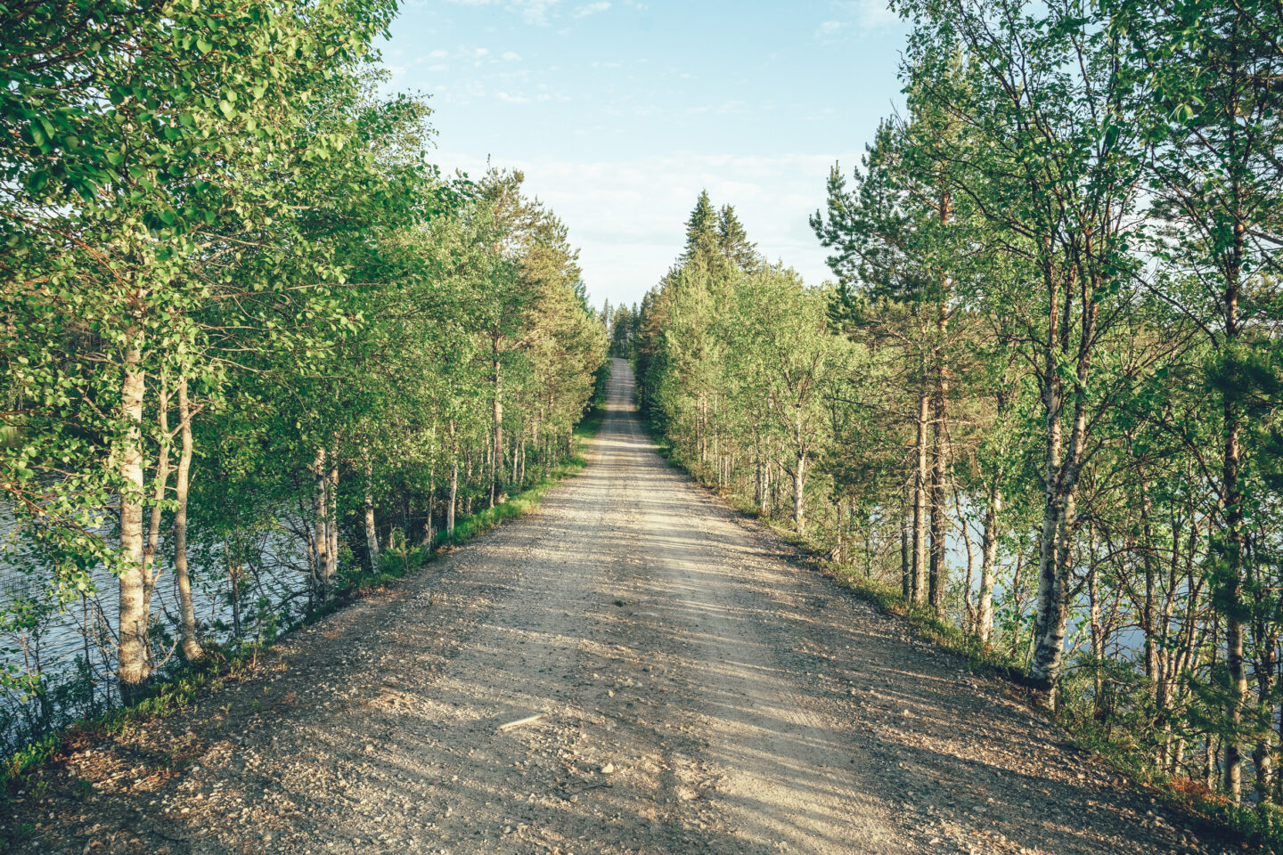 hiekkatie jossa järvi molemmilla puolilla